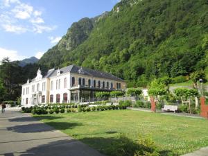 un gran edificio frente a una montaña en Charmante maison familiale 7 chambres à Cauterets - FR-1-234-244, en Cauterets