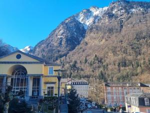 een gebouw in een stad met een berg op de achtergrond bij Studio 4 personnes centre Cauterets à 600m télécabines - FR-1-234-319 in Cauterets