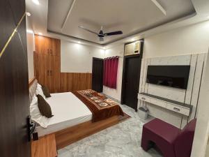 Un dormitorio con una cama y un televisor de pantalla plana. en The Golden Inn, en Lucknow