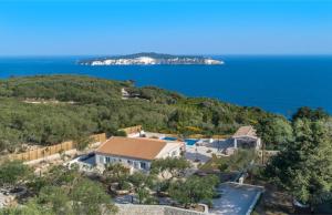 - une vue aérienne sur une maison située sur une colline à côté de l'océan dans l'établissement Villa Moundela, à Katsimátika