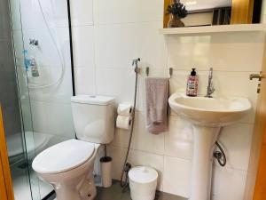 a bathroom with a toilet and a sink and a shower at Pousada Maritimus in Barretos