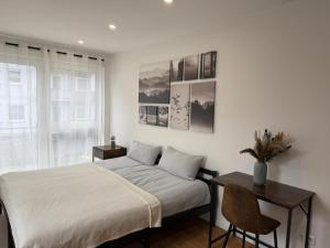 a bedroom with a bed and a table and a window at Global Bnb - Ay Homes in Friedberg