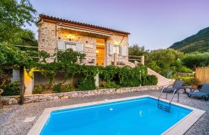 a house with a swimming pool in front of a house at Amalthia Cottage in Vathi, Ithaka