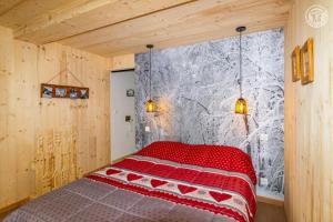 a bedroom with a red bed in a room at Romy in Aillon-le-Jeune +6 photos