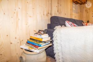 a stack of books sitting on a table next to a couch at Romy in Aillon-le-Jeune
