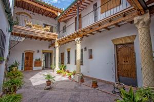 een binnenplaats met een groot gebouw met houten deuren en potplanten bij Multi Apartamentos La Kasbah in Jerez de la Frontera