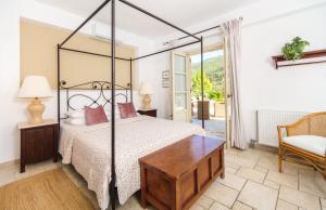 een slaapkamer met een bed, een tafel en een stoel bij Villa Athina in Ayios Nikitas