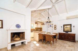 een keuken met een open haard en een tafel en stoelen bij Villa Athina in Ayios Nikitas