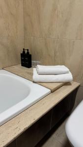 Un baño con lavabo y bañera con toallas. en Atico Finisterre, en Finisterre