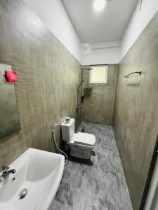 a bathroom with a white toilet and a sink at Bael House Ahangama in Ahangama