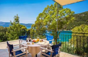 una mesa en un balcón con vistas al agua en Rhodia Beach Villa, en Stavros