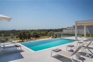a swimming pool with lounge chairs and a pool at Villa Stellina in Karavádhos +10 photos