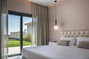 a bedroom with a white bed and a large window at Villa Stellina in Karavádhos