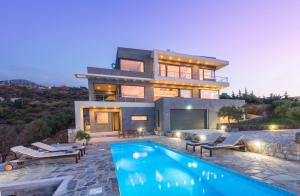 a house with a swimming pool in front of it at Villa Isidora in Sitia