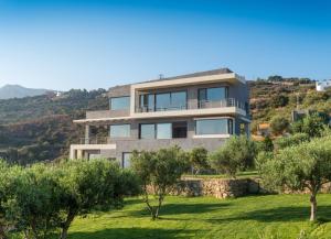 a house on top of a hill with trees at Villa Isidora in Sitia