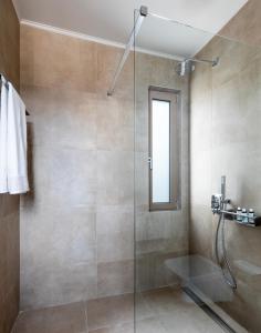 een badkamer met een douche met een glazen deur bij Villa Noesis in Katomérion +20 foto's