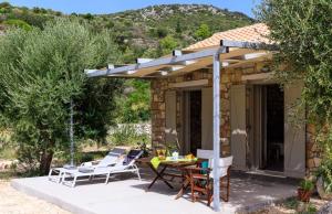 Loutsa Waterside في فاثي: فناء تحت طاولة وكراسي