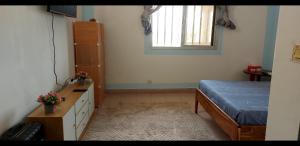 una camera da letto con un letto, una scrivania e una finestra di studio Zen 1 a Ziguinchor