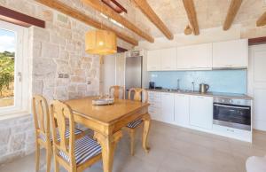 The Yiameli Collection - Yasmi في Skinária: مطبخ مع طاولة وكراسي خشبية