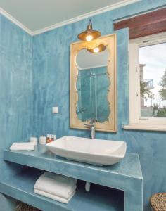 The Yiameli Collection - Yasmi في Skinária: حمام أزرق مع حوض ومرآة