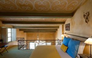 Un dormitorio con una cama grande con almohadas azules. en Le Maria Venezia, en LʼÎle-Rousse