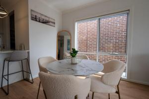 a dining room with a table and chairs and a brick wall at Ari Luxe Retreat in Lara