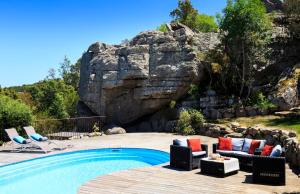 una piscina con sedie e parete di roccia di Villa Alzitella a Sotta