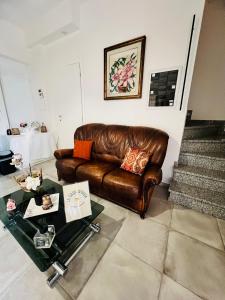 Affittacamere LA CASA DI GIADA a 3 minuti dal casello autostradale di Imola - parcheggio privato e self check-in في إيمولا: غرفة معيشة مع أريكة جلدية وطاولة +112 صورة