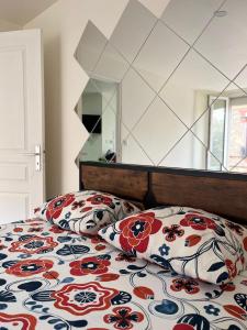 Appartements & Spa Orly Paris في فيلنوف سان جورج: غرفة نوم بها سرير ووسادتين عليه