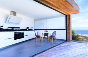 a kitchen with a table and chairs and a large window at Villa Supranu in Viggianello
