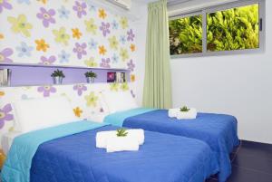 two blue beds in a room with flowers on the wall at Sivota Senses - Villa Loukas in Sivota
