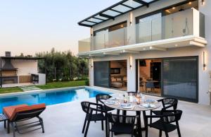 una zona pranzo all'aperto con tavolo e sedie accanto a una casa di Torretta - Harmonia a Lygia