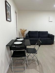 Appartements & Spa Orly Paris في فيلنوف سان جورج: غرفة معيشة مع طاولة سوداء وكراسي