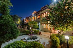 a building with a fountain in the middle of a courtyard at Chomu Bagh Hotel & Resorts in Chomu in Jaipur