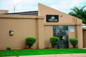 a building with a sign for a resort lobby at Sunshine Lodge in Mthatha +4 photos