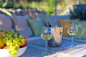 two glasses of wine and a bowl of grapes on a table at Villa Alba in Vathi, Ithaka