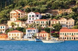 two boats are docked in the water in front of houses at Villa Alba in Vathi, Ithaka +9 photos