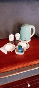 a tea pot and cups on a wooden shelf at Grand Leisure Care & Wellness Resort in Negombo