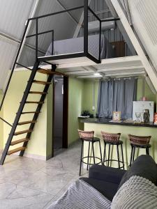 a loft bed in a room with a bar and stools at Chalés Portal das Chácaras in Brejo Sêco