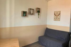 eine Ecke eines Zimmers mit einem blauen Sofa in der Unterkunft Gîte Studio Les Oliviers in Narbonne + 7 Fotos