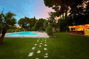 einen Hinterhof mit Pool und grünem Gras in der Unterkunft Gîte Studio Les Oliviers in Narbonne