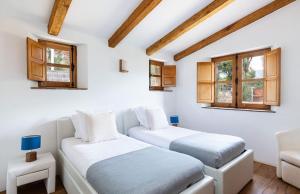 twee bedden in een kamer met witte muren en ramen bij U Caseddu in Sotta +23 foto's