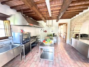 Villa Mille Desideri في أنغياري: مطبخ كبير مزود بأجهزة من الفولاذ المقاوم للصدأ وأرضية من الطوب