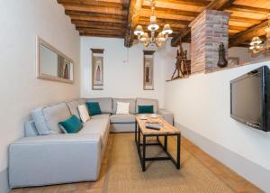 Villa Mille Desideri في أنغياري: غرفة معيشة مع أريكة وتلفزيون