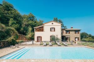 een uitzicht op een huis en een zwembad bij Villa Forconi in Lisciano Niccone