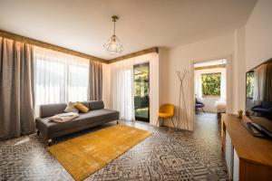 een woonkamer met een bank en een tv bij goldfinger + suites in Lana