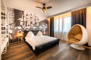 een slaapkamer met een groot bed en een stoel bij goldfinger + suites in Lana +275 foto's
