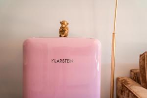 a toy monkey sitting on top of a pink flask at goldfinger + suites in Lana