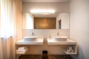 a bathroom with two sinks and a mirror at goldfinger + suites in Lana +161 photos