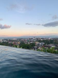 a infinity pool with a view of a city at Studentpark apartment by RD in Yogyakarta
